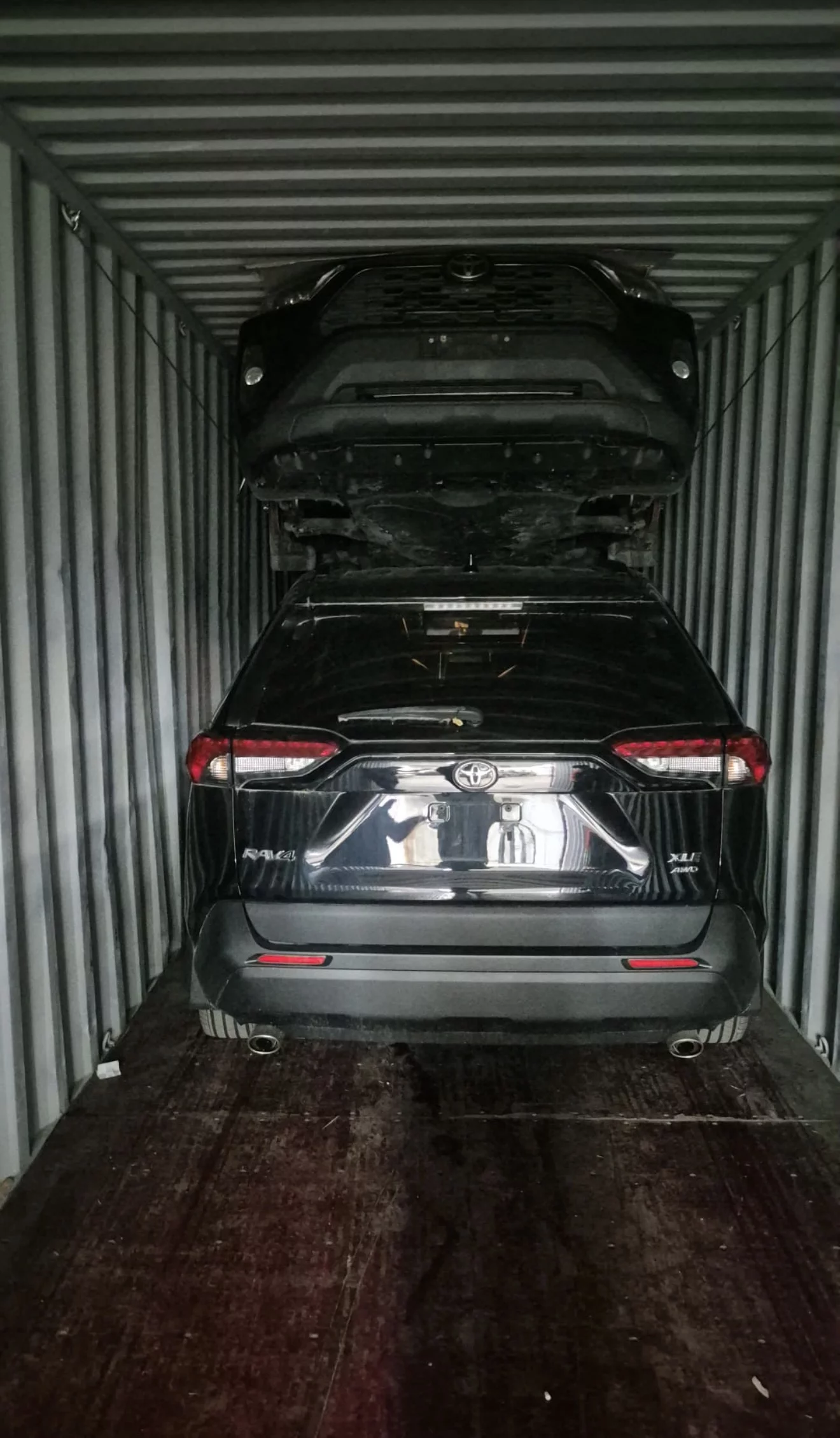 Two Toyota RAV4 SUVs loaded in shipping container