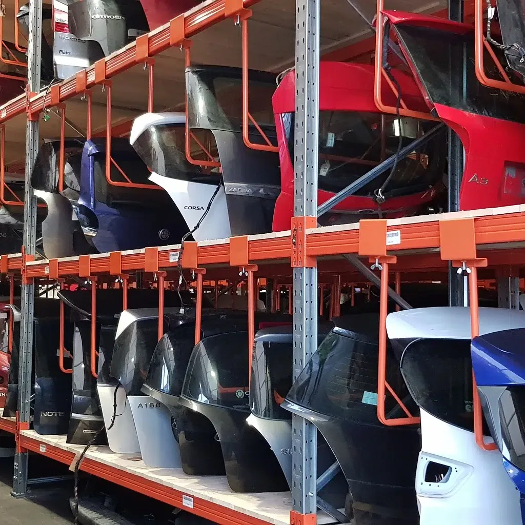 Warehouse shelves stocked with vehicle tailgates and body panels